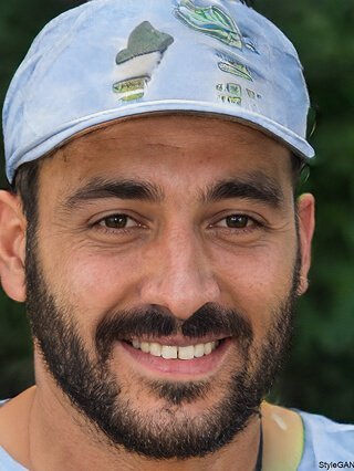 رجل يبتسم وهو يرتدي قبعة ويظهر شعار وانبي للدفع الإلكتروني.